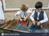 two-boys-try-hand-washing-clothes-on-the-washboard-washing-laundry-E7RANX.jpg